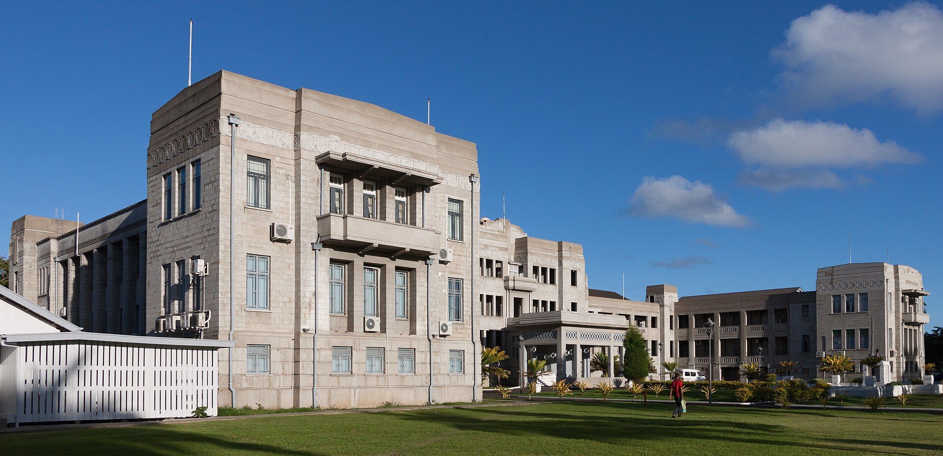 Edificios de gobierno de Fiyi en Suva, de piedra clara y estilo art déco, bajo un cielo azul