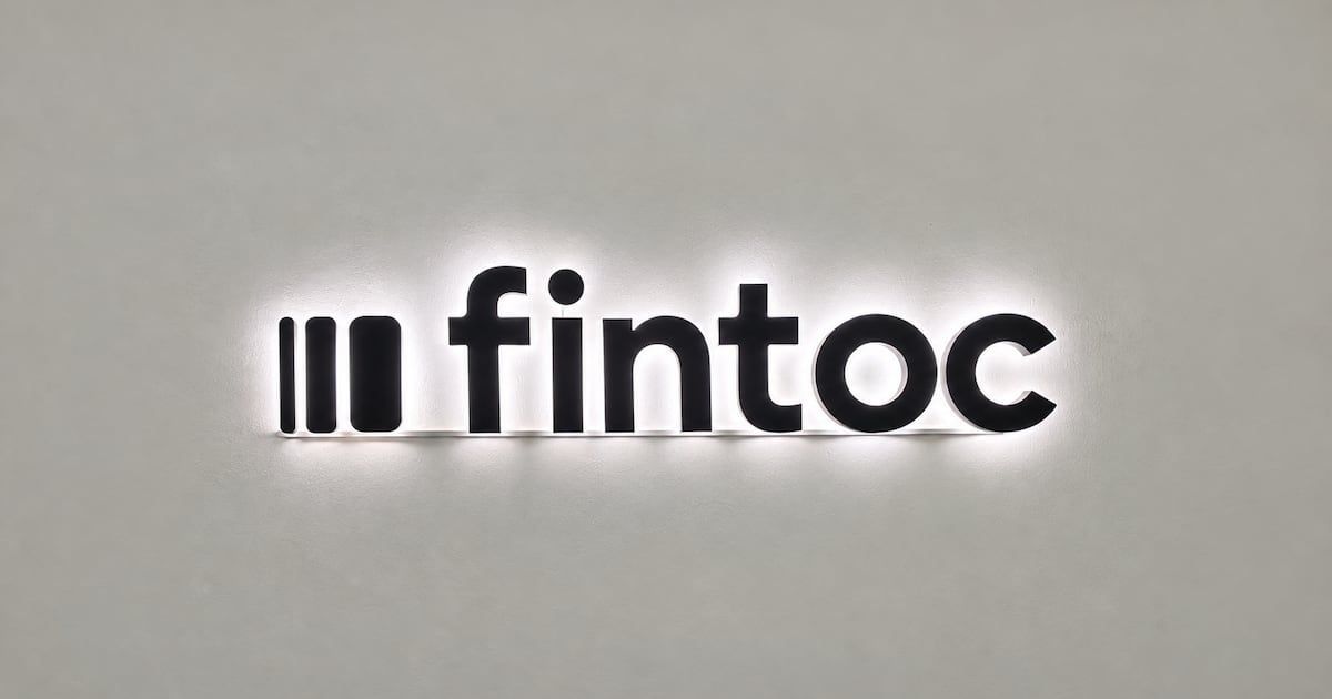 Letrero luminoso con el logo de Fintoc en letras negras sobre una pared gris clara