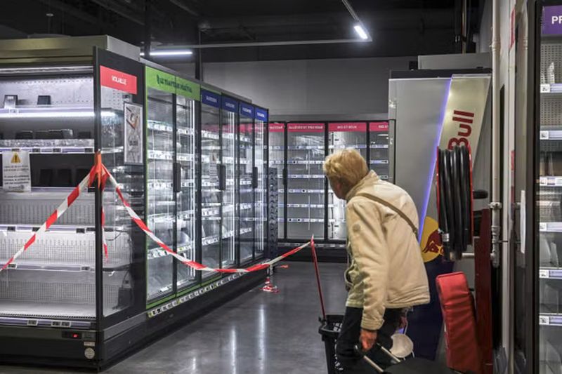 Heladeras vacías y cerradas con cinta de seguridad en un supermercado de Francia durante el ciberataque a los sistemas de frío