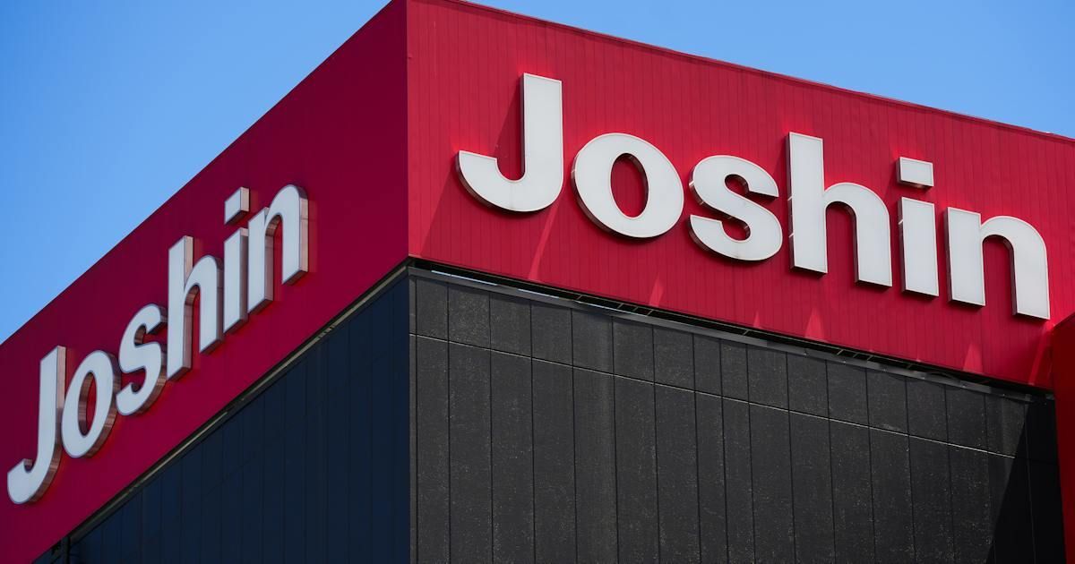 Fachada roja de una tienda de la cadena de electrodomésticos Joshin con el nombre de la marca en letras blancas