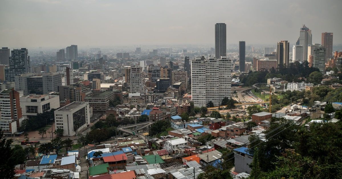 Vista panorámica de Bogotá con sus rascacielos al fondo y barrios de casas bajas en primer plano