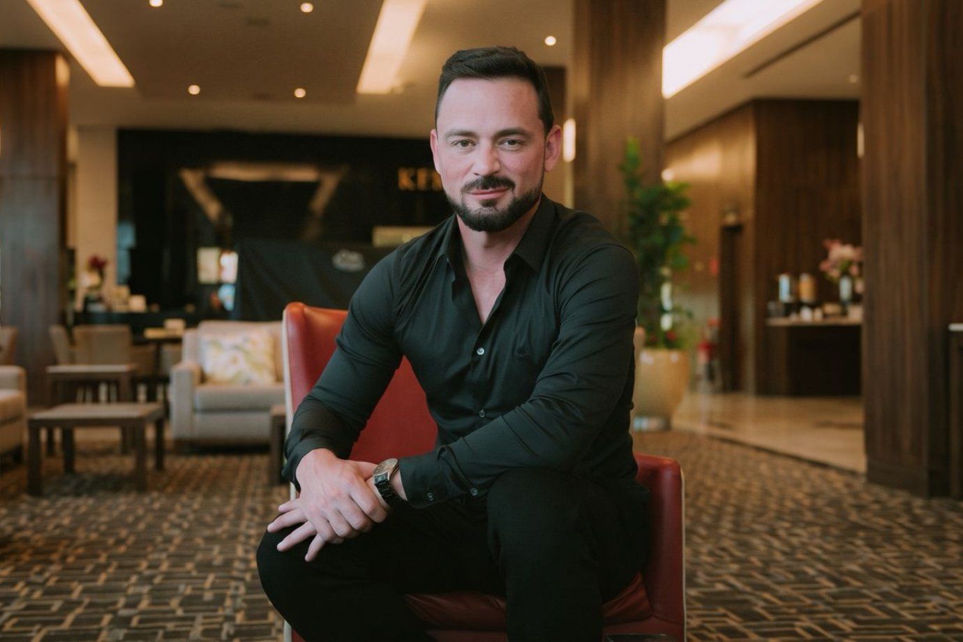 Eduardo Koetz, fundador de ADVBOX, sentado en un sillón rojo en el lobby de un hotel