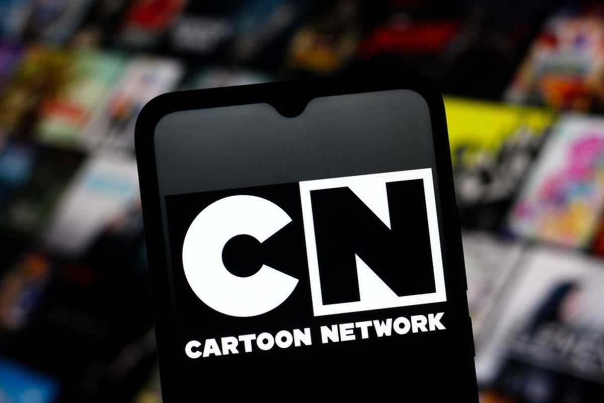 Celular con el logo de Cartoon Network en pantalla, delante de una pared desenfocada de afiches de series animadas